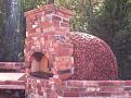 The back side of the oven with stucco and tile applied.  My daughter and I made these tiles at the local ceramics center.  They fired them at a very high cone (?) and promised me they would withstand the winters in Iowa.  Fingers crossed!