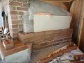 Cut bricks lengthwise and laid them attached with mortar to the board and adjacent bricks.